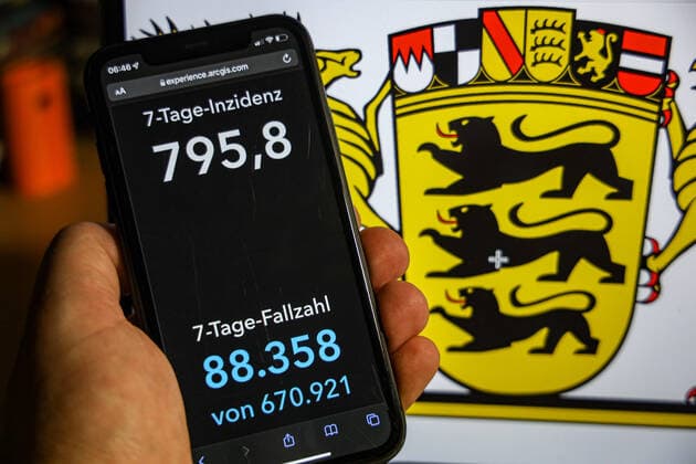 Coronavirus in Deutschland - Covid-19-Dashboard des Robert Koch-Institut DEU, Deutschland, Baden-Württemberg 23.01.2022: Die 7-Tage-Inzidenz für das Bundesland (Fälle letzte 7 Tage 100.000 EW) wird auf einem iPhone angezeigt, im Hintergrund das Landeswappen