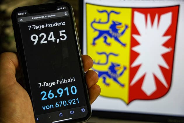 Coronavirus in Deutschland - Covid-19-Dashboard des Robert Koch-Institut DEU, Deutschland, Schleswig-Holstein 23.01.2022: Die 7-Tage-Inzidenz für das Bundesland (Fälle letzte 7 Tage 100.000 EW) wird auf einem iPhone angezeigt, im Hintergrund das Landeswappen