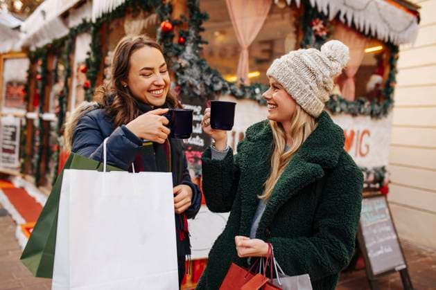 Smiling women toasting mulled wine mug at Christmas Market model released, DAWF02407