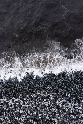 Creative Highlights World Splashing sea at coastline with pebbles at Rocha da Relva beach, WWF05934