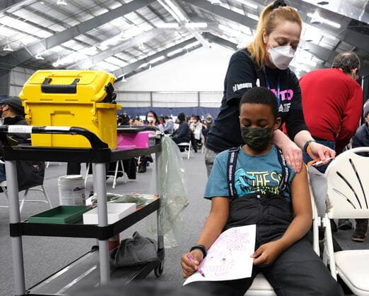 News Bilder des Tages January 23, 2022, Toronto, ON, Canada: Nine-year-old Mpho Sebape colours with crayons as gets his dose of COVID-19 vaccine at a clinic in Toronto on Sunday Jan. 23, 2022. Toronto officials officially opened a one-day COVID-19 vaccination mega-clinic in the city s northwest on Sunday. Toronto Canada  - ZUMAc35_ 20220123_zaf_c35_032 Copyright: xR.J.xJohnstonx