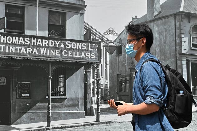 NSW CORONAVIRUS COVID19, People wearing masks walk in front of a construction site featuring archival images of Sydney plastered on the wall in Sydney, Tuesday, January 25, 2022. ( NO ARCHIVING, EDITORIAL USE ONLY, NO USE IN BOOKS WITHOUT CONSENT SYDNEY NSW AUSTRALIA  Copyright: xx 20220125001616798869