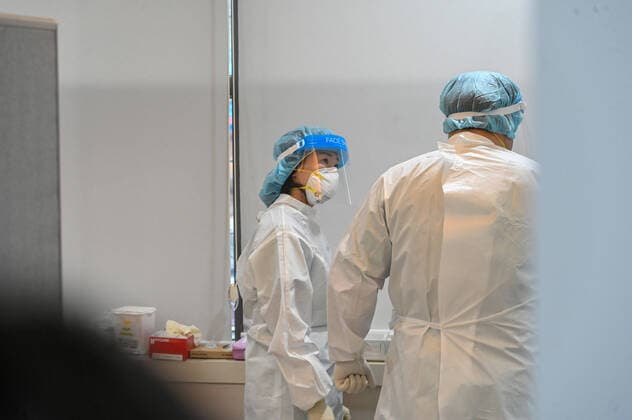 Healthcare workers in protective gear consult at an outpatient COVID-19 clinic at Gyeonggi Provincial Medical Center Anseong Hospital in Anseong, South Korea, a city near Seoul, on January 25, 2022. South Korea is facing a surge of cases driven by the Omicron variant and is shifting its virus management strategy.  SEO2022012504 THOMASxMARESCA