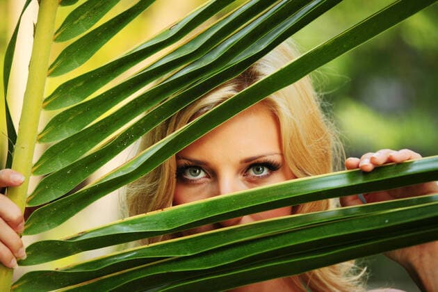 woman hiding behind the palm leaves Copyright: xx 2691849
