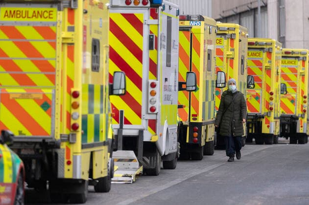 (220129) -- LONDON, Jan. 29, 2022 -- Photo taken on Jan. 28, 2022 shows a woman walking past ambulances parked outside the Royal London Hospital in London, Britain. A new form of Omicron named BA.2 has been designated a variant under investigation, with 426 cases of the Omicron variant sub-lineage confirmed in the United Kingdom (UK), the UK Health Security Agency (UKHSA) said Friday. (Photo by Xinhua) BRITAIN-LONDON-COVID-19-OMICRON RayxTang 