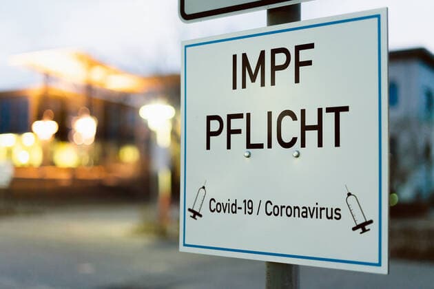 Schild mit der Aufschrift Impfpflicht - Covid 19 Coronavirus Pflicht zur Impfung Symbolbild - FOTOMONTAGE