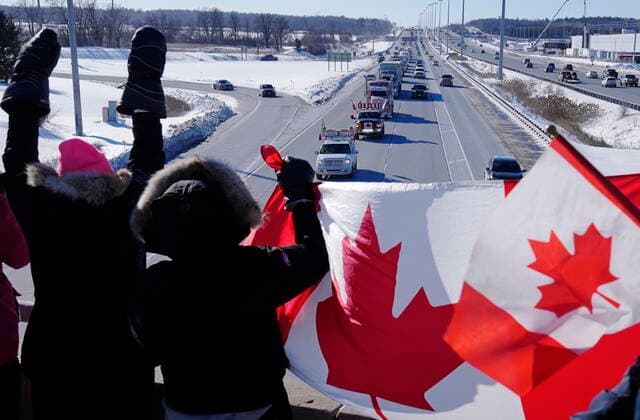 January 29, 2022, Ottawa, ON, Canada: Supporters wave flags on an overpass in Kanata, Ont., as a trucker convoy making it s way to Parliament Hill in Ottawa to participate in a cross-country truck convoy protesting measures taken by authorities to curb the spread of COVID-19 and vaccine mandates passes by on Saturday, Jan. 29, 2022. Ottawa Canada  - ZUMAc35_ 20220129_zaf_c35_099 Copyright: xFrankxGunnx