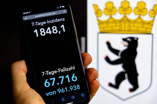 Coronavirus in Deutschland - Covid-19-Dashboard des Robert Koch-Institut DEU, Deutschland, Berlin 30.01.2022: Die 7-Tage-Inzidenz für das Bundesland (Fälle letzte 7 Tage 100.000 EW) wird auf einem iPhone angezeigt, im Hintergrund das Landeswappen