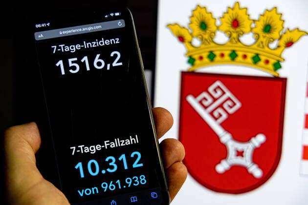 Coronavirus in Deutschland - Covid-19-Dashboard des Robert Koch-Institut DEU, Deutschland, Bremen 30.01.2022: Die 7-Tage-Inzidenz für das Bundesland (Fälle letzte 7 Tage 100.000 EW) wird auf einem iPhone angezeigt, im Hintergrund das Landeswappen