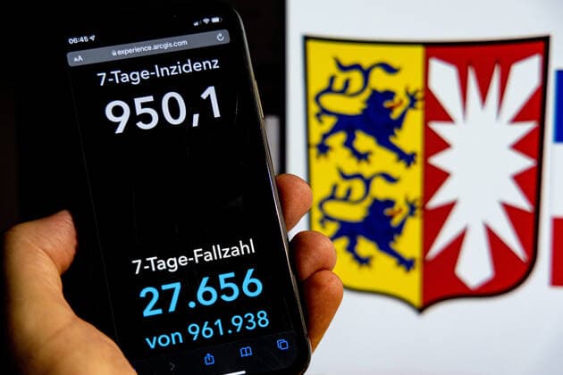 Coronavirus in Deutschland - Covid-19-Dashboard des Robert Koch-Institut DEU, Deutschland, Schleswig-Holstein 30.01.2022: Die 7-Tage-Inzidenz für das Bundesland (Fälle letzte 7 Tage 100.000 EW) wird auf einem iPhone angezeigt, im Hintergrund das Landeswappen