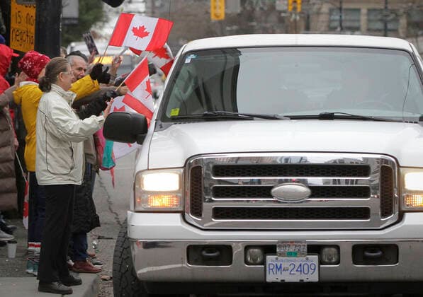 (220130) -- VANCOUVER, Jan. 30, 2022 -- Protestors wave flags as vehicles run along the street during a parade in support of Ottawa s Freedom Convoy trucker protest in downtown Vancouver, British Columbia, Canada, Jan. 29, 2022. Vehicles jammed downtown Vancouver streets Saturday to show their support of the Freedom Convoy of long-haul drivers to oppose the Canadian government s requirement that all cross-border essential workers, including truckers, must show proof of vaccination at a port of entry. (Photo by Xinhua) CANADA-VANCOUVER-FREEDOM CONVOY-SUPPORT-PARADE LiangxSen 
