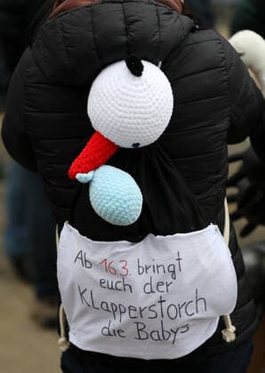 Erfurt - Grossdemo gegen die Impfpflicht 29.01.2022, Erfurt, Thueringer Staatskanzlei, Grossdemo unter dem Motto Gemeinsam gegen die Impfpflicht u.a. demonstriert das Pflegepersonal gegen die fuer den 15.03.2022 beschlossene Impfpflicht fuer Pflegekraefte im Bild: Hebamme mit Storch auf dem Ruecken und einem Rucksack mit der Aufschrift Ab 16.03. bringt euch der Klapperstorch die Babys *** Erfurt large demonstration against the vaccination obligation 29 01 2022, Erfurt, Thuringia State Chancellery, large demonstration under the slogan Together against the vaccination obligation among other things demonstrates the care personnel against the vaccination obligation for care forces decided for 15 03 2022 in the picture midwife with stork on