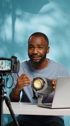IMAGO Creative: Digitale Welt, Social Commerce African american blogger reviewing studio light on camera African american blogger reviewing studio light on camera for vlog channel. Black influencer doing recommendation and review product used for videography equipment on video podcast. Copyright: xx 43945796