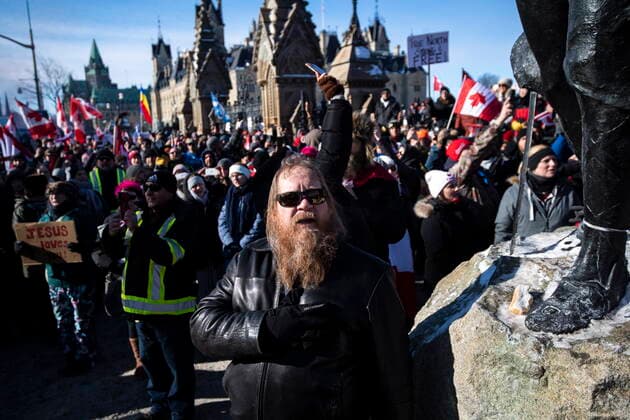 January 30, 2022, Ottawa, ON, CAN: A person holds their hand to their heart during a singing of O Canada during a rally against COVID-19 restrictions on Parliament Hill, which began as a cross-country convoy protesting a federal vaccine mandate for truckers, in Ottawa on Sunday, Jan. 30, 2022. Ottawa CAN  - ZUMAc35_ 20220130_zaf_c35_021 Copyright: xJustinxTangx