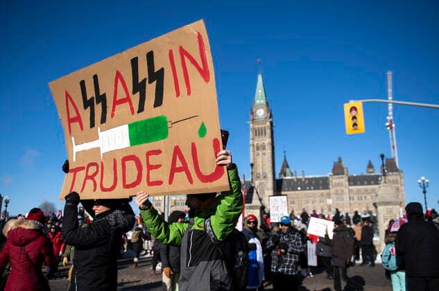 January 29, 2022, Ottawa, ON, CAN: People hold a sign against Prime Minister Justin Trudeau and vaccinations during a rally against COVID-19 restrictions on Parliament Hill, which began as a cross-country convoy protesting a federal vaccine mandate for truckers, in Ottawa, on Saturday, Jan. 29, 2022. Ottawa Canada  - ZUMAc35_ 20220129_zaf_c35_018 Copyright: xJustinxTangx