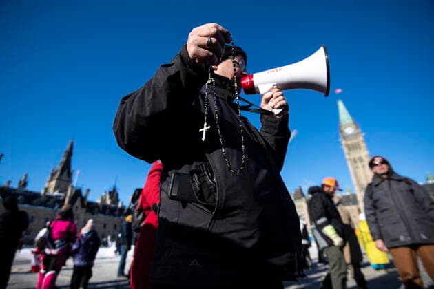 January 30, 2022, Ottawa, ON, CAN: A person leads a group in the saying of the Rosary during a rally against COVID-19 restrictions on Parliament Hill, which began as a cross-country convoy protesting a federal vaccine mandate for truckers, in Ottawa on Sunday, Jan. 30, 2022. Ottawa Canada  - ZUMAc35_ 20220130_zaf_c35_020 Copyright: xJustinxTangx