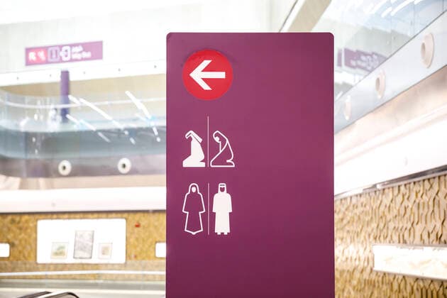 Fotoreportage Doha Katar September 2021 Ein Wegweiser zum Gebetsraum in einer U-Bahn Metro Station in Doha. Abgebildet sind Piktogramme einer Frau und eines Mannes in traditioneller landesüblicher Kleidung.