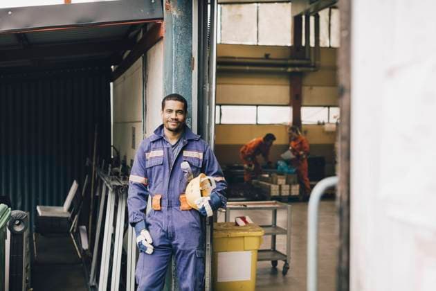 IMAGO Creative: 2022 Favoriten IMAGO Creative: Ruhe im Chaos Confident male worker holding hardhat in warehouse doorway Sweden, Stockholm, model released, property released Copyright: xMaskotx , MA91492