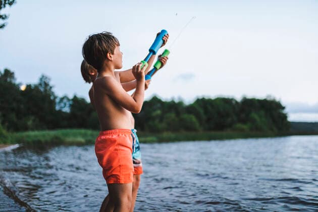 IMAGO Kreativ: Bruderschaft Shirtless siblings playing with squirt gun by sea during weekend Sweden, Gothenburg, model released Copyright: xMaskotx , MA91513