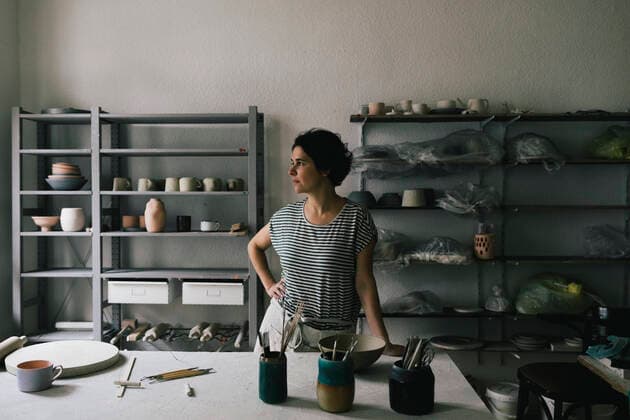 IMAGO Creative: Internationaler Frauenmonat, Gesundheit, Frauen in der Menopause Contemplative craftswoman with hand on hip standing in ceramics store Germany, Berlin, model released, property released Copyright: xMaskotx , MA92050