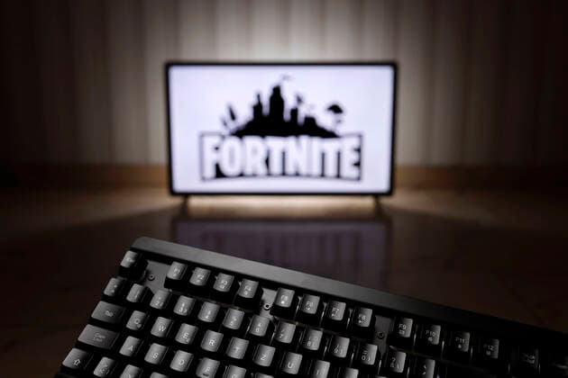 Das Logo des Survival-Shooters Fortnite auf einem Bildschirm, im Vordergrund eine Computerspiele-Tastatur. (Symbolbild, Symbolfoto) Köln, 01.02.2022 Foto:xC.xHardtx xFuturexImage