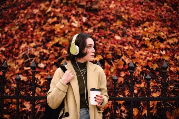 IMAGO Creative, Jahreszeit Herbst, Ferien IMAGO Creative: Ende des Sommers Young woman listening music in headphones standing in city in autumn CR_DMBE220203-885866-01 ,model released, Symbolfoto