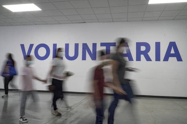 February 6, 2022: People walk past a sign that reads Voluntary as they await to get vaccinated. The Salvadoran Ministry of Health announced it had surpassed 10 million vaccine doses applied. - ZUMAf143 20220206_zip_f143_007 Copyright: xCamiloxFreedmanx