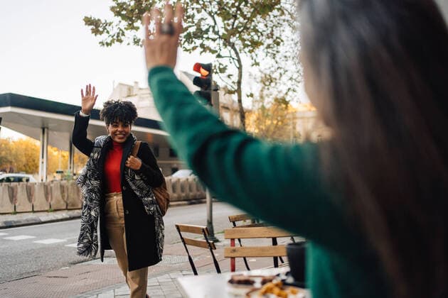 IMAGO Creative, Urban Lifestyle IMAGO Creative: Urban Diversity Hispanic female waving hand to excited African American friend while sitting at table with desserts in street cafe JakeJakab_EliAlicia_25.jpg Copyright: xJakexJakabx Model Released