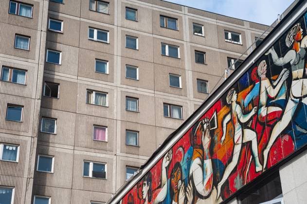 05.02.2022, Berlin, Deutschland, Europa - DDR-Fries (Wandmosaik) mit dem Titel Die Presse als Organisator am ehemaligen Pressecafe Berlin Flachbau am Alexanderplatz des Malers Willi Neubert. Daran angrenzend ein typischer Plattenbau mit Wohnungen.