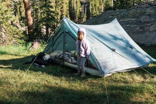 IMAGO Creative: Sommer, In den Bergen IMAGO Creative: Ende des Sommers Young girl standing in front of her tent in Colorado United States, Colorado, Leadville CR_PALI220208E9-913847-01 ,model released, Symbolfoto