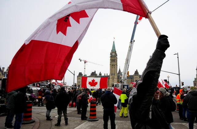 February 11, 2022, Ottawa, ON, CAN: A person waves a Canadian flag in front of Parliament Hill on the 15th day of a protest against COVID-19 measures that has grown into a broader anti-government protest, in Ottawa, Friday, Feb. 11, 2022. Ottawa CAN  - ZUMAc35_ 20220211_zaf_c35_164 Copyright: xJustinxTangx