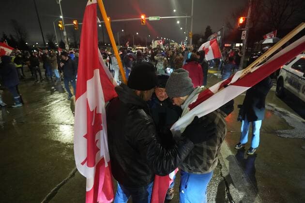 February 11, 2022, WINDSOR, ON, CANADA: People pray as truckers and supporters block the access leading from the Ambassador Bridge, linking Detroit and Windsor, as truckers and their supporters continue to protest against the COVID-19 vaccine mandates and restrictions in Windsor, Ont., on Friday, February 11, 2022. WINDSOR CANADA - ZUMAc35_ 20220211_zaf_c35_200 Copyright: xNathanxDenettex