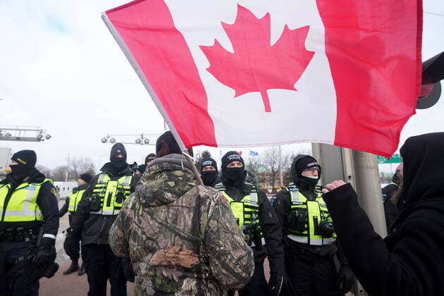 February 12, 2022, Windsor, ON, CANADA: A protester yells at police officers as demonstrators prepare to leave in advance of police enforcing an injunction against their demonstration, which has blocked traffic across the Ambassador Bridge by protesters against COVID-19 restrictions, in Windsor, Ont., Saturday, Feb. 12, 2022. Windsor CANADA - ZUMAc35_ 20220212_zaf_c35_105 Copyright: xNathanxDenettex