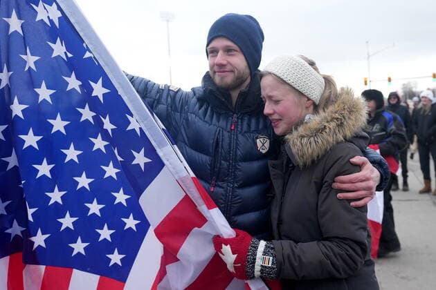 February 12, 2022, Windsor, ON, CANADA: A supporter holding an American flag cries as police officers enforce an injunction against their demonstration, which has blocked traffic across the Ambassador Bridge by protesters against COVID-19 restrictions, in Windsor, Ont., Saturday, Feb. 12, 2022. Windsor CANADA - ZUMAc35_ 20220212_zaf_c35_112 Copyright: xNathanxDenettex