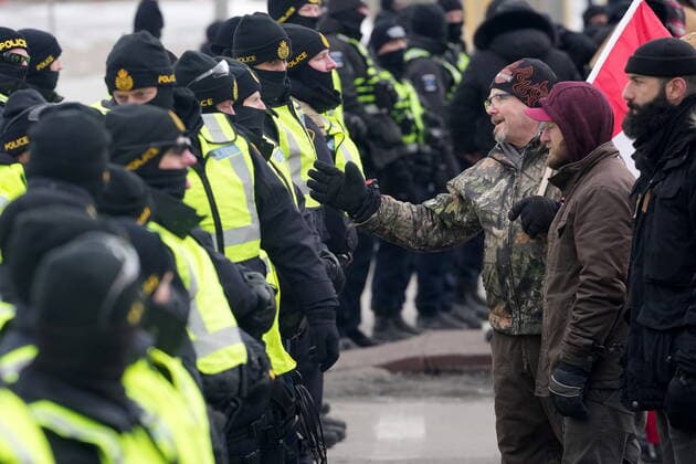 February 12, 2022, Windsor, ON, CANADA: A protester attempts to speak with police officers as they enforce an injunction against their demonstration, which has blocked traffic across the Ambassador Bridge by protesters against COVID-19 restrictions, in Windsor, Ont., Saturday, Feb. 12, 2022. Windsor CANADA - ZUMAc35_ 20220212_zaf_c35_128 Copyright: xNathanxDenettex