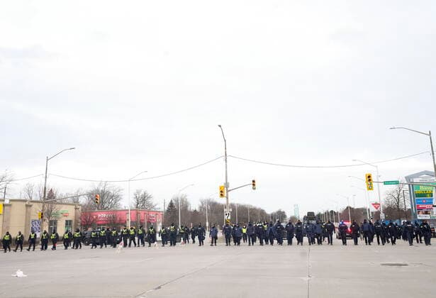 February 13, 2022, WINDSOR, ON, CANADA: Police walk the line to remove all truckers and supporters after a court injunction gave police the power to enforce the law after protesters blocked the access leading from the Ambassador Bridge, linking Detroit and Windsor, as truckers and their supporters continue to protest against COVID-19 vaccine mandates and restrictions, in Windsor, Ont., Sunday, Feb. 13, 2022. WINDSOR CANADA - ZUMAc35_ 20220213_zaf_c35_039 Copyright: xNathanxDenettex