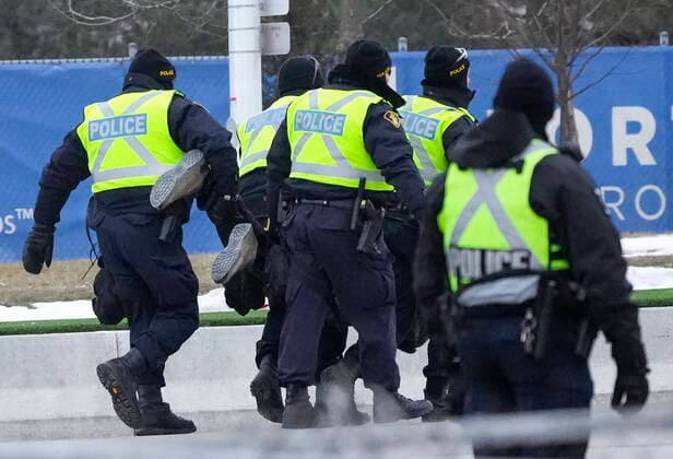 February 13, 2022, WINDSOR, ON, CANADA: Police arrest a person as they walk the line to remove all truckers and supporters after a court injunction gave police the power to enforce the law after protesters blocked the access leading from the Ambassador Bridge, linking Detroit and Windsor, as truckers and their supporters continue to protest against COVID-19 vaccine mandates and restrictions, in Windsor, Ont., Sunday, Feb. 13, 2022. WINDSOR CANADA - ZUMAc35_ 20220213_zaf_c35_041 Copyright: xNathanxDenettex