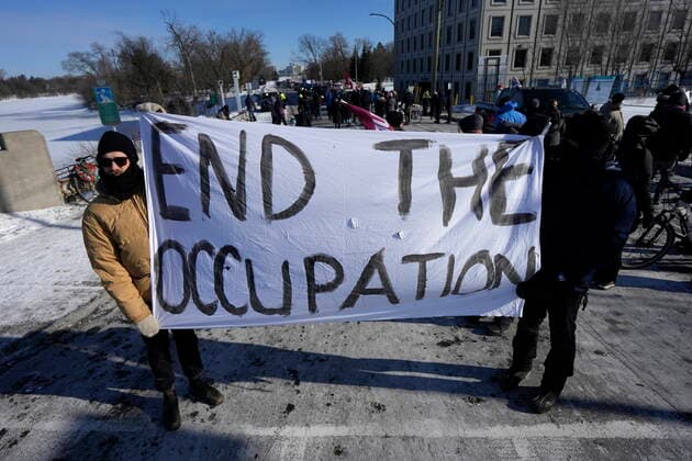 February 13, 2022, Ottawa, ON, CAN: People hold a sign as residents participate in a counter protest to stop vehicles from driving in a convoy en route to Parliament Hill, on the 17th day of a protest against COVID-19 measures that has grown into a broader anti-government protest, in Ottawa, Sunday, Feb. 13, 2022. Ottawa CAN  - ZUMAc35_ 20220213_zaf_c35_059 Copyright: xJustinxTangx