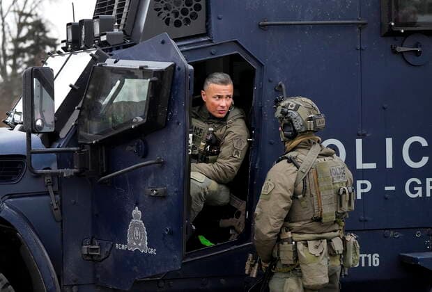 February 13, 2022, WINDSOR, ON, CANADA: Two RCMP tactical unit officers monitor the situation as police remove truckers and supporters after a court injunction gave police the power to enforce the law after protesters blocked the access leading from the Ambassador Bridge, linking Detroit and Windsor, as truckers and their supporters continue to protest against COVID-19 vaccine mandates and restrictions, in Windsor, Ont., Sunday, Feb. 13, 2022. WINDSOR CANADA - ZUMAc35_ 20220213_zaf_c35_047 Copyright: xNathanxDenettex