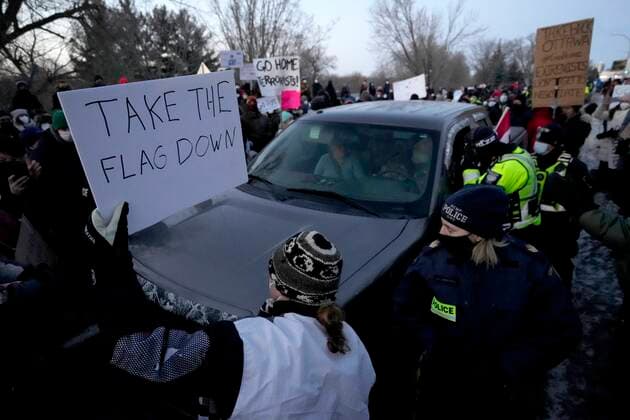 February 13, 2022, Ottawa, ON, CAN: A resident holds a sign calling for a convoy participant to remove their Canadian flag as they negotiate to release vehicles from a counter protest that blocked Riverside Drive for hours, in Ottawa, Sunday, Feb. 13, 2022. The protest, which began as a cross country convoy against COVID-19 measures but has manifested into a broader anti-government protest, has been marked by the sound of truck horns and the waving of the Canadian flag, sometimes upside down, which residents argued was a co-opting of the flag. Ottawa CAN - ZUMAc35_ 20220213_zaf_c35_118 Copyright: xJustinxTangx