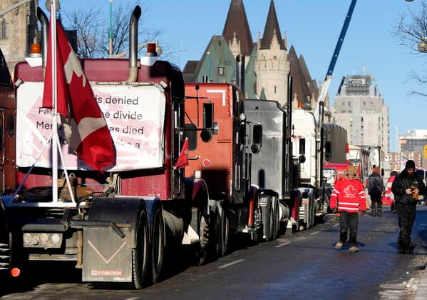 February 14, 2022, Ottawa, ON, CAN: A person wears a Team Canada hockey jersey as Wellington Street is lined with trucks once again after city officials negotiated to move some trucks towards Parliament and away from downtown residences, on the 18th day of a protest against COVID-19 measures that has grown into a broader anti-government protest, in Ottawa, on Monday, Feb. 14, 2022. Ottawa CAN  - ZUMAc35_ 20220214_zaf_c35_158 Copyright: xJustinxTangx