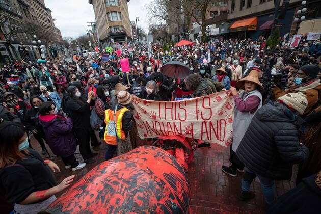 February 14, 2022, VANCOUVER, BC, CANADA: People gather around the Gassy Jack statue after it was toppled and covered in red paint during the annual Women s Memorial March, in Vancouver, on Monday, February 14, 2022. The statue is a monument to Gassy Jack Deighton, a Vancouver saloon owner in the 1860s, whom Vancouver s Gastown neighbourhood is named after. The march is held to honour missing and murdered women and girls from the community with stops along the way to commemorate where women were last seen or found. VANCOUVER CANADA - ZUMAc35_ 20220214_zaf_c35_169 Copyright: xDarrylxDyckx