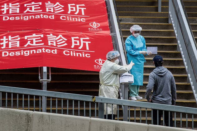 February 16, 2022, Hong Kong, Hong Kong: Health care workers pre-screen a man seeking entrance to the Shau Kei Wan Designated COVID-19 Clinic. .In response to the exponential rise in COVID-19 cases that are overloading Hong Kong s hospitals, the government has set up designated clinics across the city to handle those who test positive. The clinics are intended to treat those with mild symptoms, with daily quotas established and a soon-to-be launched taxi transport program. Hong Kong is currently in the fifth phase of the pandemic, recording thousands of new cases per day. Hong Kong Hong Kong - ZUMAs197 20220216_zaa_s197_029 Copyright: xBenxMaransx