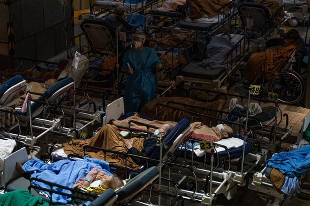 Hong Kong s COVID-19 Infections Soar On February 16, 2022, in a temporary shelter outside Caritas Medical Center in Hong Kong, China, a patient lies in a hospital bed waiting for medical treatment. The temperature drops at night. The patient is put on thermal insulation products and medical staff take care of the patient. The Food and Health Bureau confirmed a new record of 4,285 infections, while 7,000 people initially tested positive, a near-record high. At least 12,000 infected people are waiting to be admitted to hospitals as COVID-19 cases overwhelm the public health system. Hong Kong China  Copyright: xLeungxManxHeix originalFilename: manhei-notitle220216_npcnR.jpg