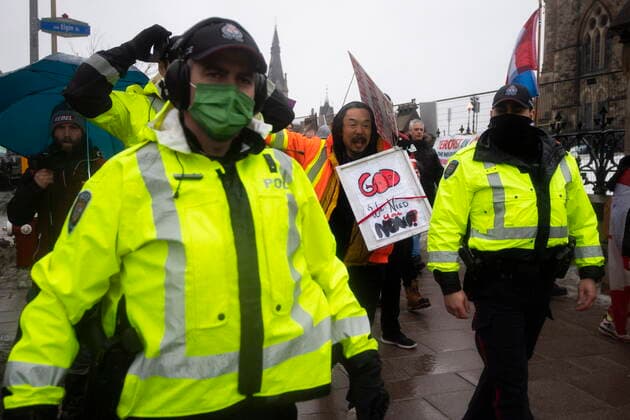 February 17, 2022, Ottawa, ON, CAN: Police are followed by yelling protesters as they attempt to hand out a notices to protesters on the 21st day of a protest against COVID-19 measures that has grown into a broader anti-government protest, in Ottawa, on Thursday, Feb. 17, 2022. Ottawa CAN  - ZUMAc35_ 20220217_zaf_c35_067 Copyright: xJustinxTangx