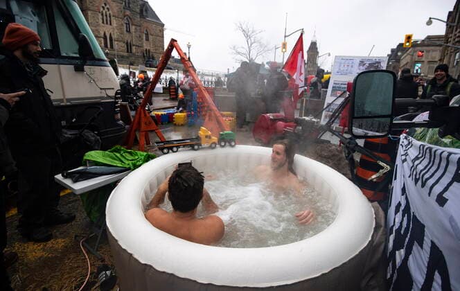 February 17, 2022, Ottawa, ON, CAN: Protesters go for a soak in an inflatable hot tub along Wellington Street across from West Block on Parliament Hill on the 21st day of a protest against COVID-19 measures that has grown into a broader anti-government protest, in Ottawa, on Thursday, Feb. 17, 2022. Ottawa CAN  - ZUMAc35_ 20220217_zaf_c35_071 Copyright: xJustinxTangx