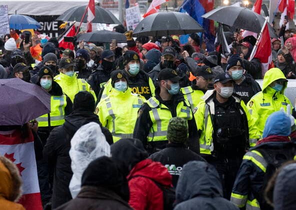 February 17, 2022, Ottawa, ON, Canada: Police walk between protesters gathered near a stage as a protest against COVID-19 measures, that has grown into a broader anti-government protest, continues to occupy downtown Ottawa, Thursday, Feb. 17, 2022. Ottawa Canada  - ZUMAc35_ 20220217_zaf_c35_170 Copyright: xAdrianxWyldx