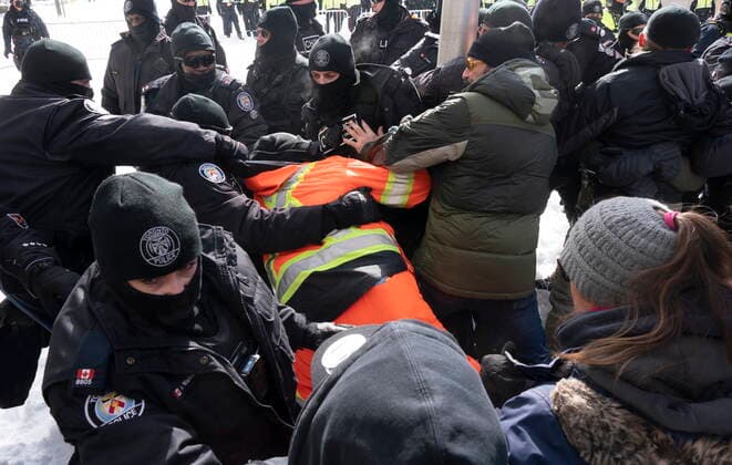 Kanada, Protest gegen Corona-Maßnahmen in Ottawa - Polizei beginnt mit Räumung von LKW-Blockade February 18, 2022, Ottawa, ON, Canada: Police pull a man behind their lines as they work to end a protest, which started in opposition to mandatory COVID-19 vaccine mandates and grew into a broader anti-government demonstration and occupation, in Ottawa, Friday, Feb. 18, 2022. Ottawa Canada - ZUMAc35_ 20220218_zaf_c35_130 Copyright: xAdrianxWyldx