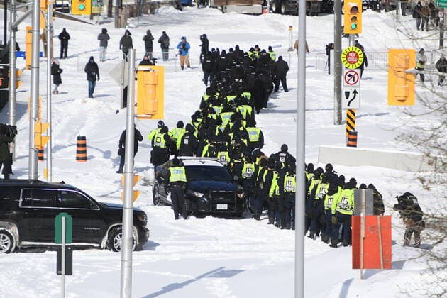 February 18, 2022, Ottawa, Canada: A lineup of police officers assemble on Colonel By Drive near the truck blockade in Ottawa, on Friday. Ottawa Canada  - ZUMAc35_ 20220218_zaf_c35_091 Copyright: xJustinxTangx