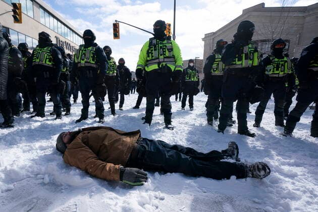 February 18, 2022, Ottawa, Canada: A protester lies down in front of police as they advance to end a protest, which started in opposition to mandatory COVID-19 vaccine mandates and grew into a broader anti-government demonstration and occupation, in Ottawa, Friday. Ottawa Canada  - ZUMAc35_ 20220218_zaf_c35_129 Copyright: xAdrianxWyldx